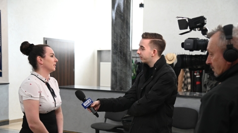 
                                        Pani w białej bluzce i czarnej spódnicy udziela wywiadu przed kamerą TVP                                        