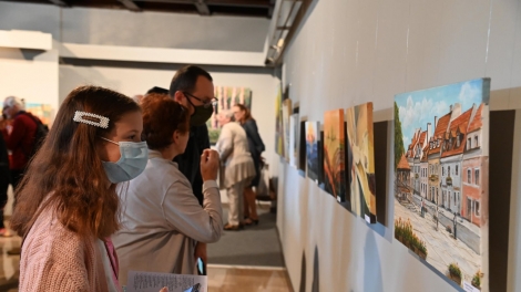 
                                        Goście wystawy oglądają obrazy                                        